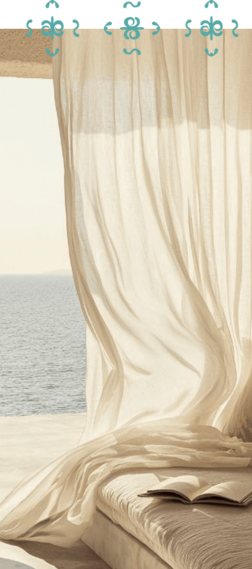 Sheer white curtains billowing with an ocean view beyond